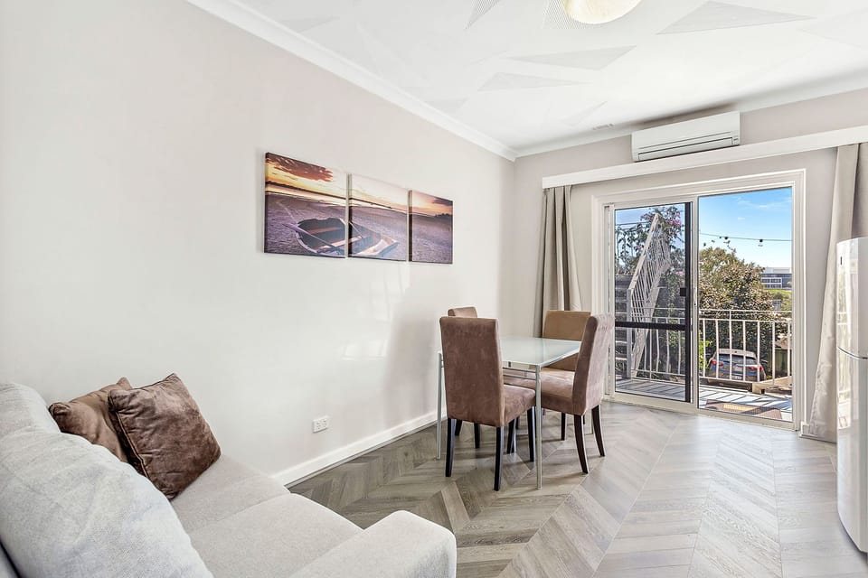 Comfortable and airy living space with natural light and a dining area for four.