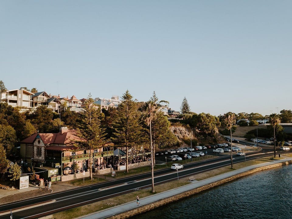 A quiet suburban road flanked by trees and homes, offering a glimpse into relaxed everyday life.