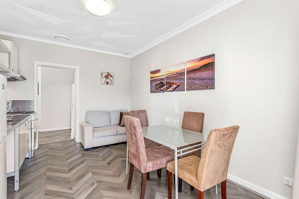 Relax and unwind in this open-plan living space, featuring a comfortable seating area and a dining table perfect for enjoying meals.