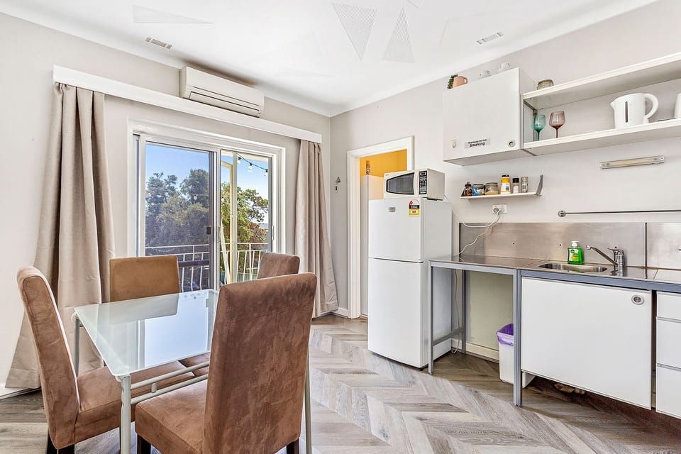 Imagine enjoying a meal at this inviting dining table, surrounded by natural light and views of the outdoors.