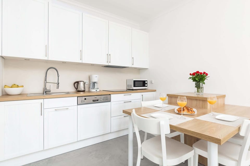 Kitchenette and dining area with table and tableware.