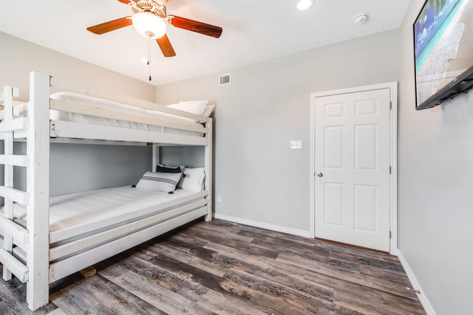 Your cozy bunk room features comfortable beds with crisp linens, warm wood floors, and entertainment—perfect for family bonding time.