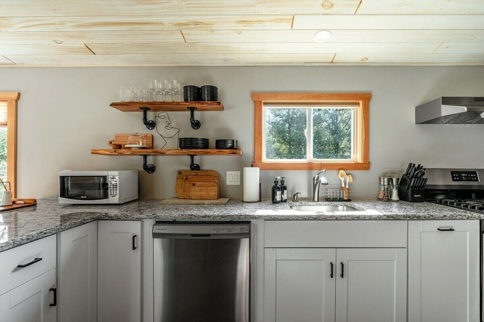 The inviting kitchen area of the cabin, complete with modern appliances and a spacious layout perfect for cooking and entertaining. The rustic wooden accents and sleek finishes make this space both stylish and functional.