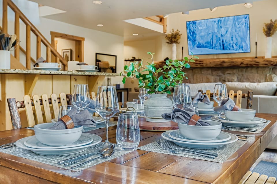 Gather for memorable meals around the rustic dining table beneath the charming antler chandelier. Enjoy the serene views in your mountain retreat.