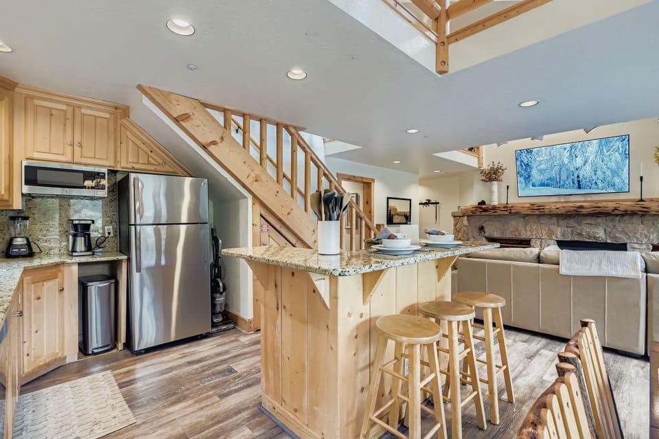 Enjoy this open-concept living area with a fully equipped kitchen and rustic dining table. Perfect for relaxing after a day exploring Park City's mountains.