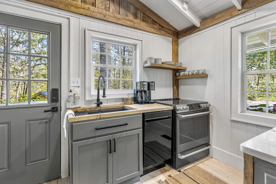 Farmhouse sink, compact dishwasher, oven and stove top.