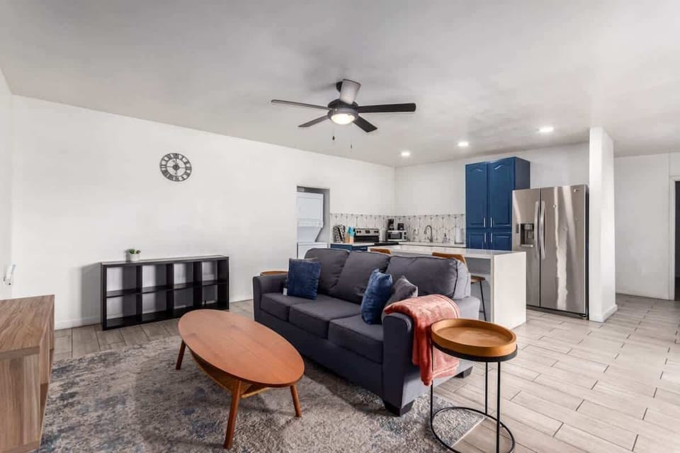 Open living area with a cozy sectional, stylish decor, and ample natural light for a welcoming atmosphere.