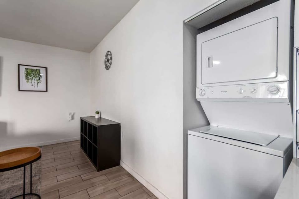 Convenient in-unit laundry area with a stacked washer and dryer, perfect for extended stays.
