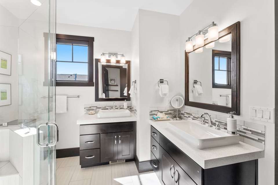 - Refresh in a bathroom with dual sinks and modern vanities  
- Glass shower and bright tile work create a spa-like atmosphere  
- Large mirrors and natural light make mornings easy and bright