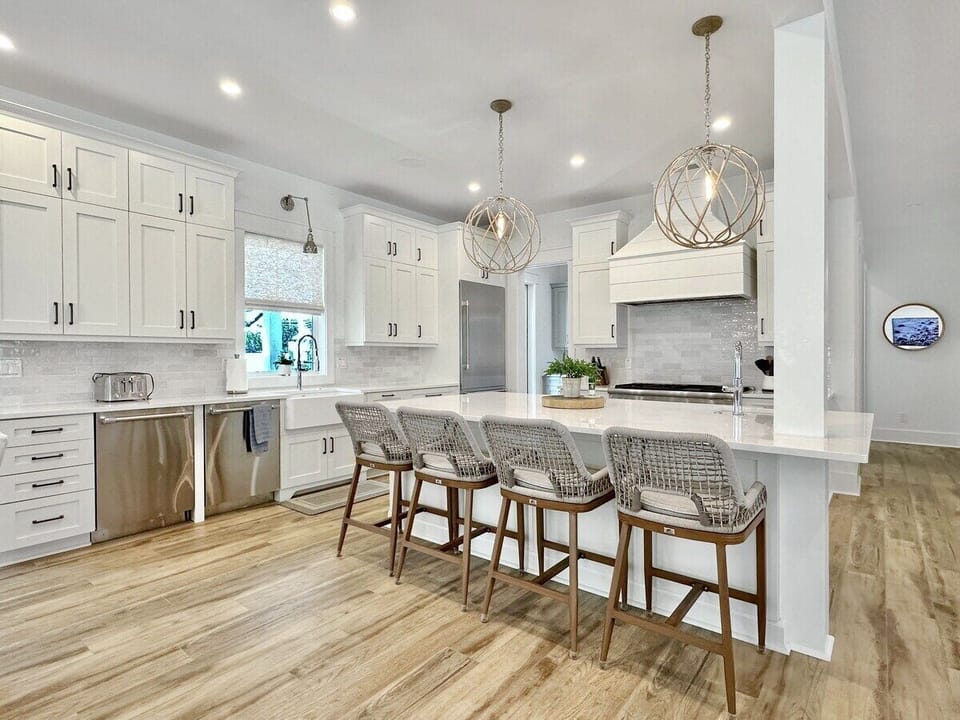 Bright and airy kitchen features TWO dishwashers, lots of prep space and seating.