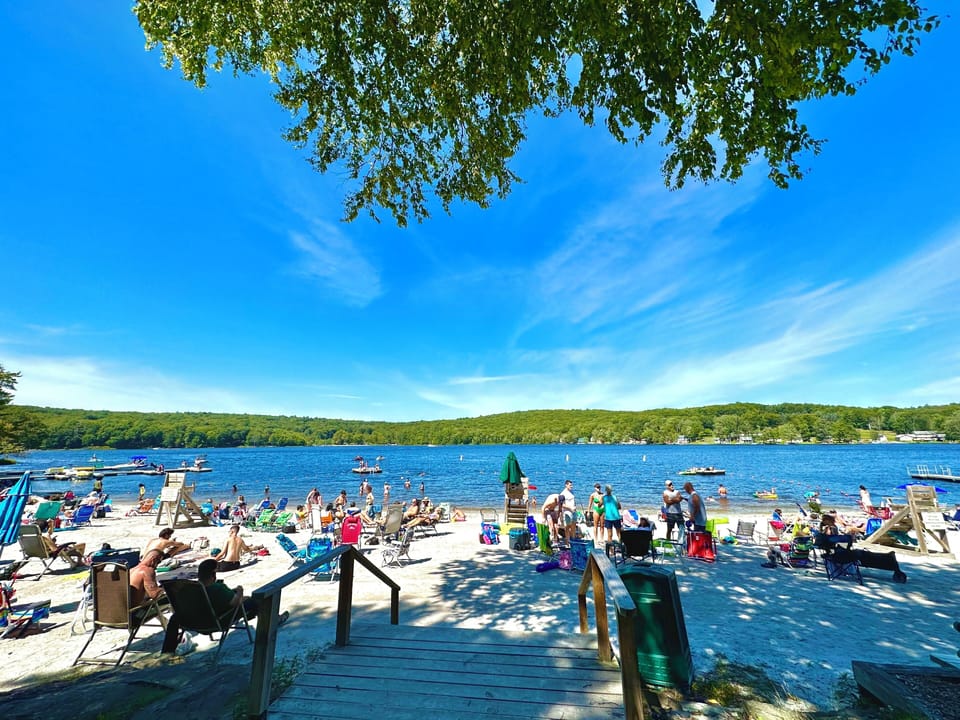 Lake view with guests enjoying boating and sun bathing.