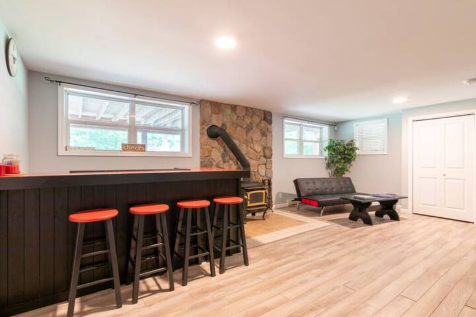 Basement with a Bar table with stools. Has small sofa as well.