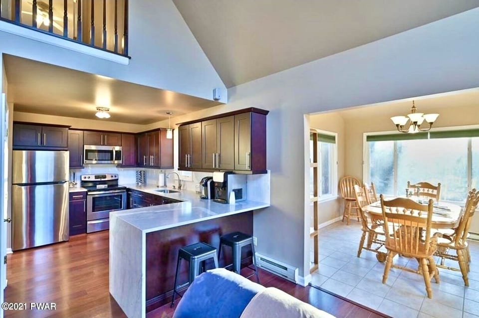 Kitchen with view of living room and sun room with Dining table with 8 chairs