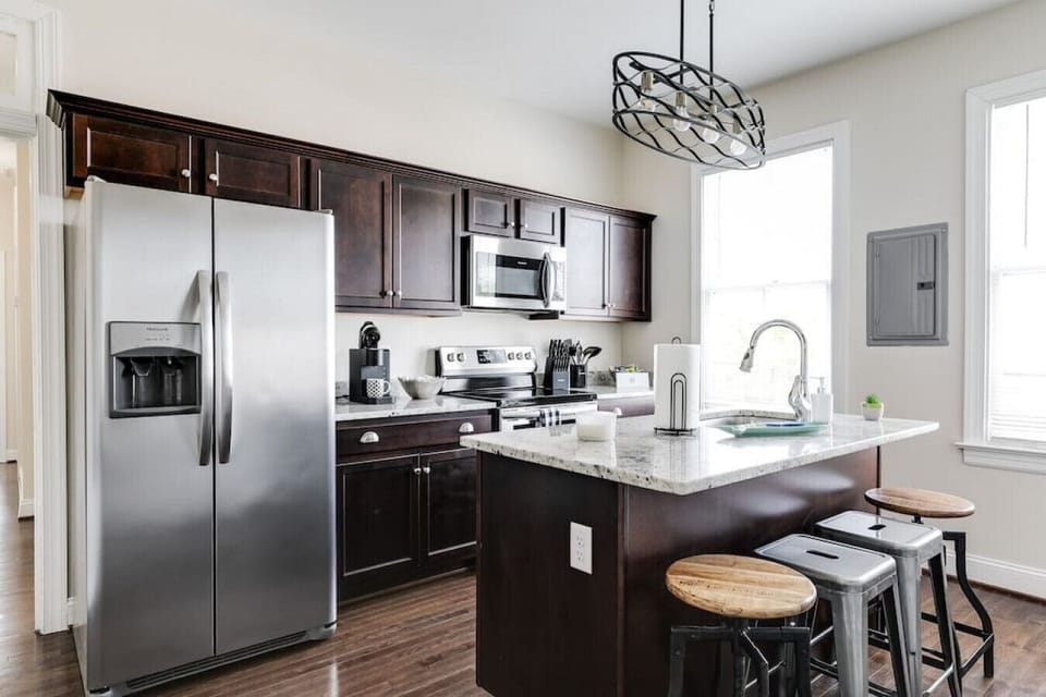 Bright, fully equipped kitchen with island seating for four, a flat‑screen TV for mealtime entertainment, full‑size fridge and freezer, oven, stove, microwave, Keurig, toaster, and all the essentials you need to cook comfortably during your stay.