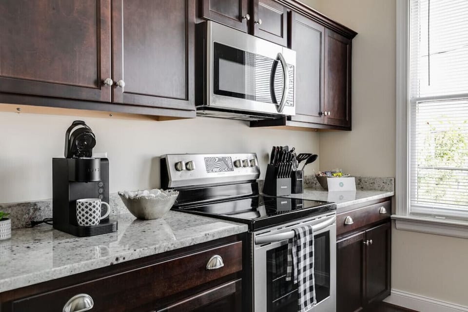 Bright, fully equipped kitchen with island seating for four, a flat‑screen TV for mealtime entertainment, full‑size fridge and freezer, oven, stove, microwave, Keurig, toaster, and all the essentials you need to cook comfortably during your stay.