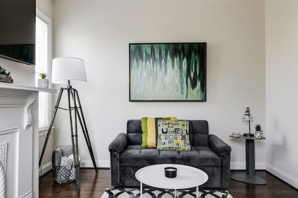 Stylish, cozy living room featuring a flat‑screen Roku TV, full‑size pull‑out sofa, seating for four, and a convenient desk area — perfect for relaxing or getting a little work done.