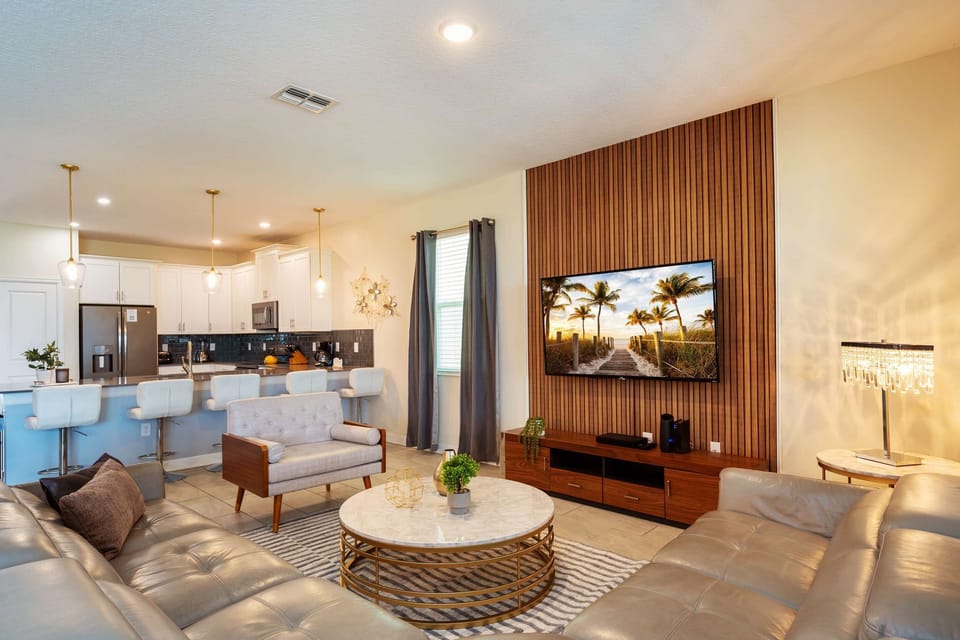 Spacious open-plan living area with plush seating and a sleek kitchen, ideal for entertaining and relaxation.