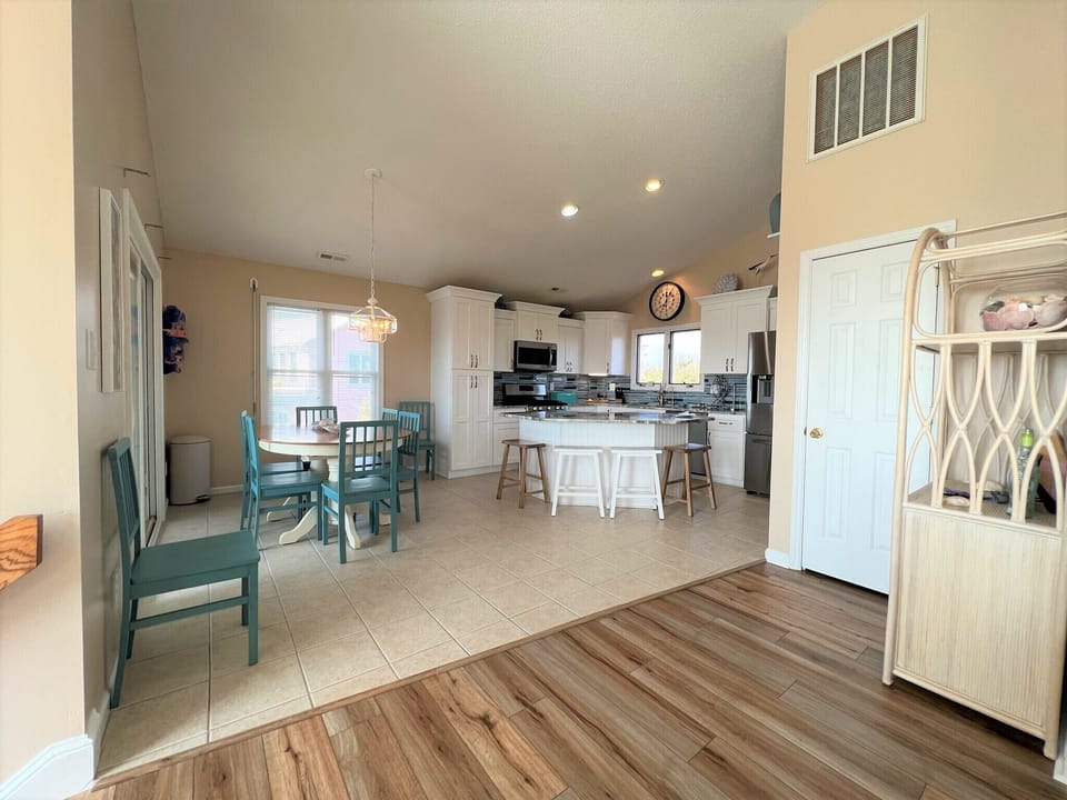 Step into your bright, open kitchen and dining space where turquoise chairs add coastal charm to your coastal getaway.