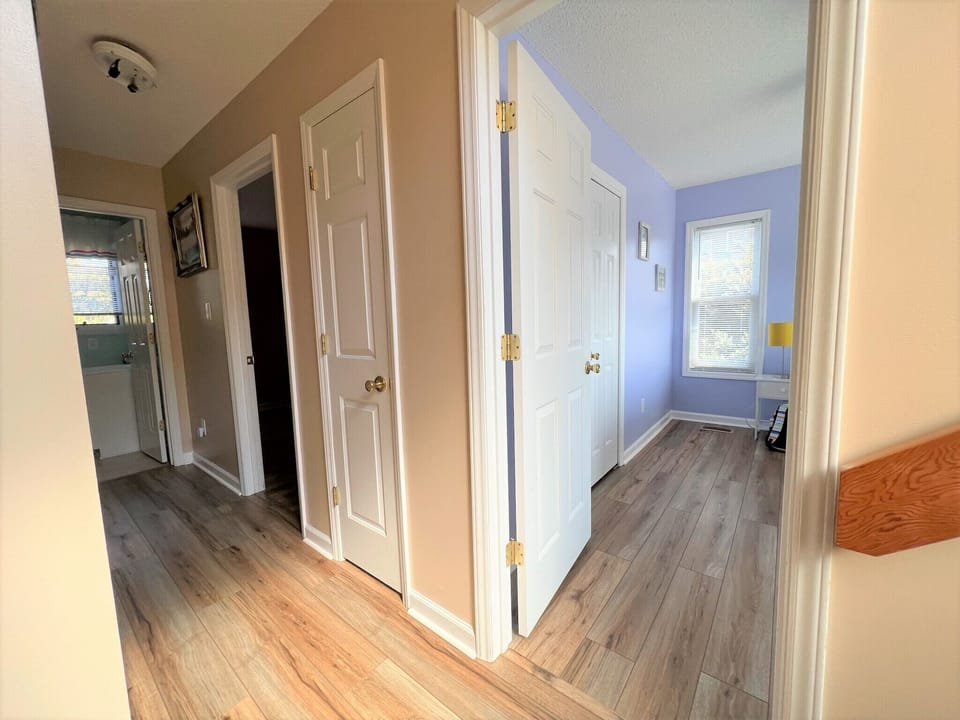 Step into your welcoming hallway where warm colors and gleaming wood floors guide you through the home's thoughtfully designed spaces.