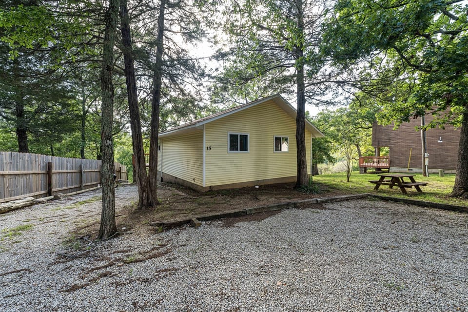 Cabin 15 has a picnic table and a charcoal grill