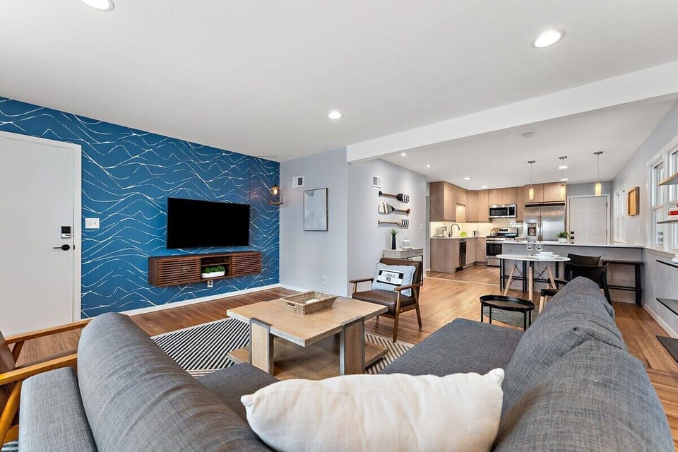 Living room with 55" Smart TV, pull-out sofa and two lounge chairs