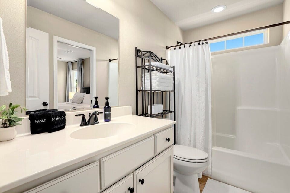 This shared bathroom has a single sink, plenty of counter space and a combination tub + shower.