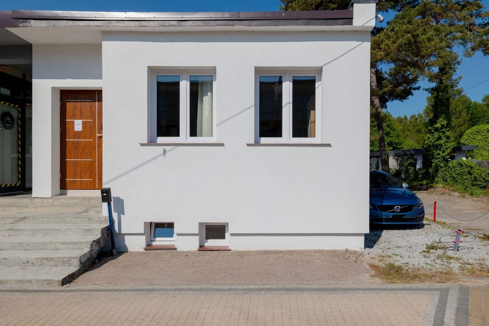 The front exterior of the house, showcasing a simple, clean design with a small outdoor area.
