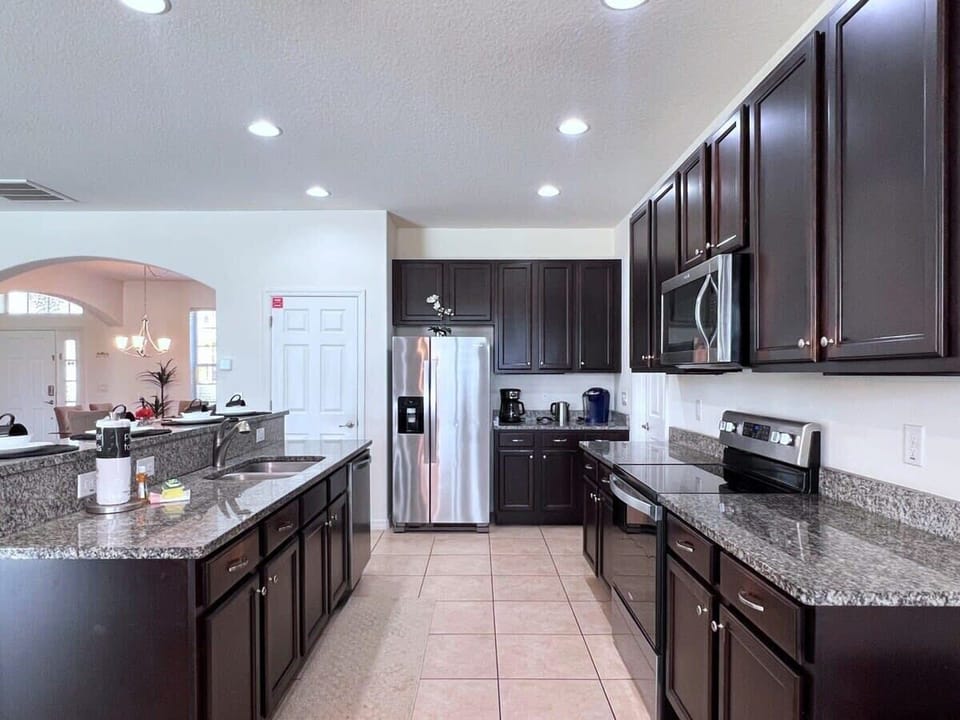 The open-concept kitchen features stainless steel appliances, ample counter space, and everything you need to prepare family meals during your vacation.