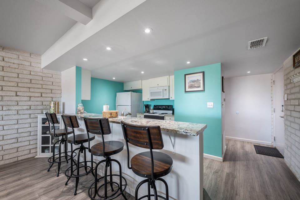 Your fully equipped kitchen features granite countertops and stylish bar seating where you can gather for meals and memories.