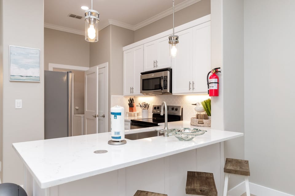 Your fully equipped kitchen features modern appliances and elegant white countertops, perfect for preparing meals during your stay.