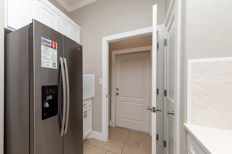 Your spacious kitchen boasts modern stainless steel appliances and elegant white cabinetry, creating the perfect space for preparing memorable meals.
