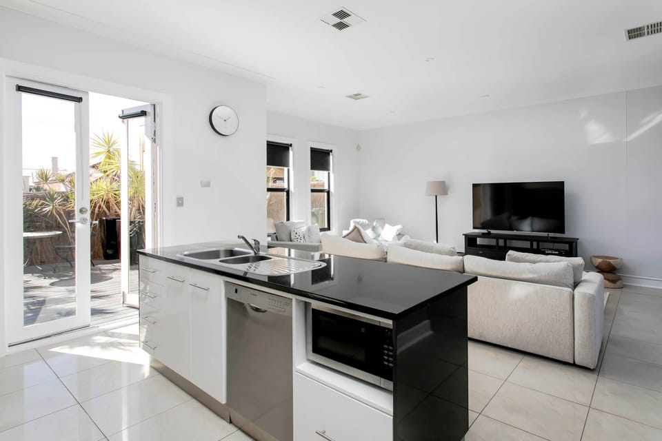 Kitchen - view through glass doors to front decked courtyard (private & secure).