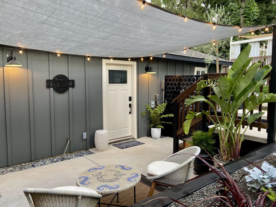 Shade sail + bistro lights, with patio seats at your own private space