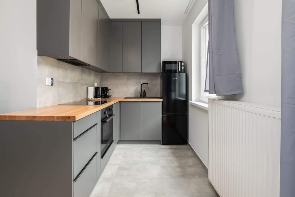 A compact yet fully equipped kitchen with sleek cabinetry, an integrated oven, and modern appliances.
