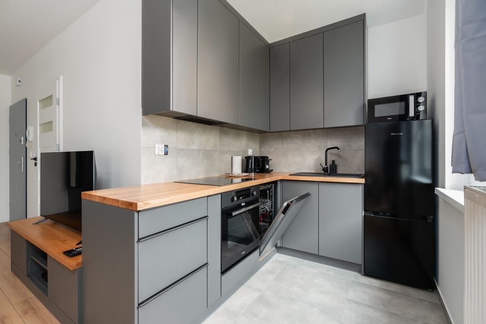 A kitchen with wooden countertops and a contemporary gray finish, blending style and practicality.
