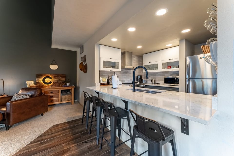 Your open-concept kitchen features sleek countertops, stainless steel appliances, and a breakfast bar perfect for morning coffee or casual meals.