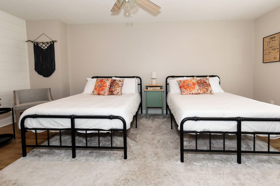 Rest peacefully in your cozy twin bedroom featuring comfortable beds with vibrant pillows, thoughtful decor, and a ceiling fan for perfect temperature control.