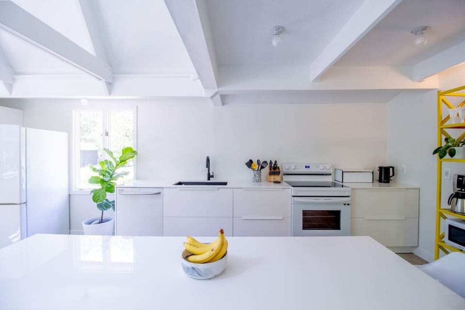 Sleek and bright fully stocked kitchen with modern essentials, pops of color, and natural light 🍌✨ #ModernKitchen #BrightSpaces #CleanDesign