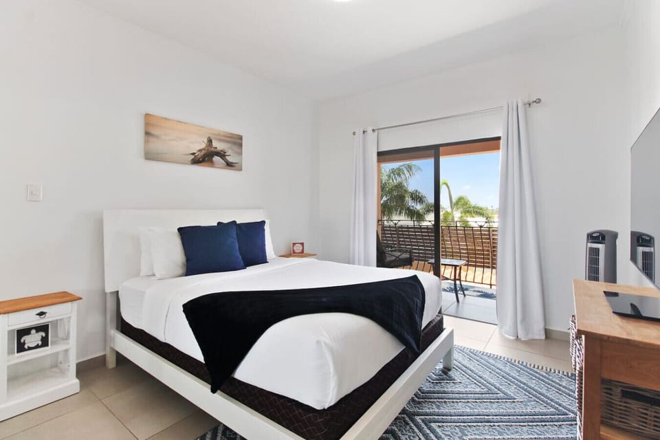 Master bedroom | Unwind in our condo`s luxurious master bedroom. Relax in the plush king size bed, enjoy stunning views from the balcony, and indulge in the convenience of the walk-in closet and en-suite bathroom.