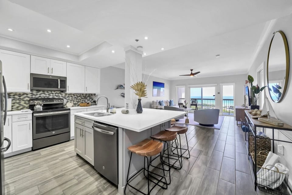 Stunning ocean-view beach condo: modern, open, and bright kitchen and living room. Pure coastal elegance. #BeachVibes