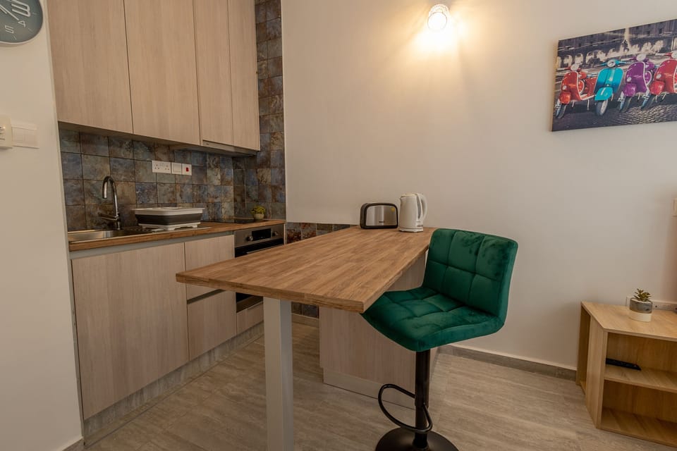 Kitchen and island bar with 2 stools and appliances (toaster, kettle)