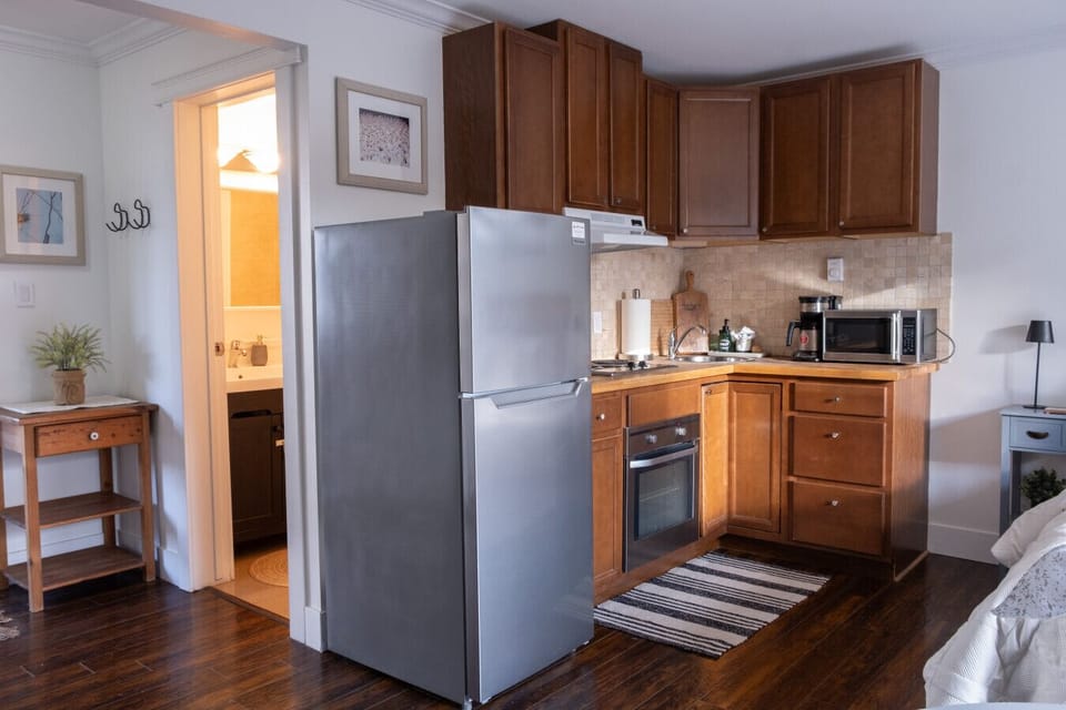 The fully stocked kitchen includes a fridge, stove, oven, microwave, toaster, coffee machine, and kitchen necessities.
