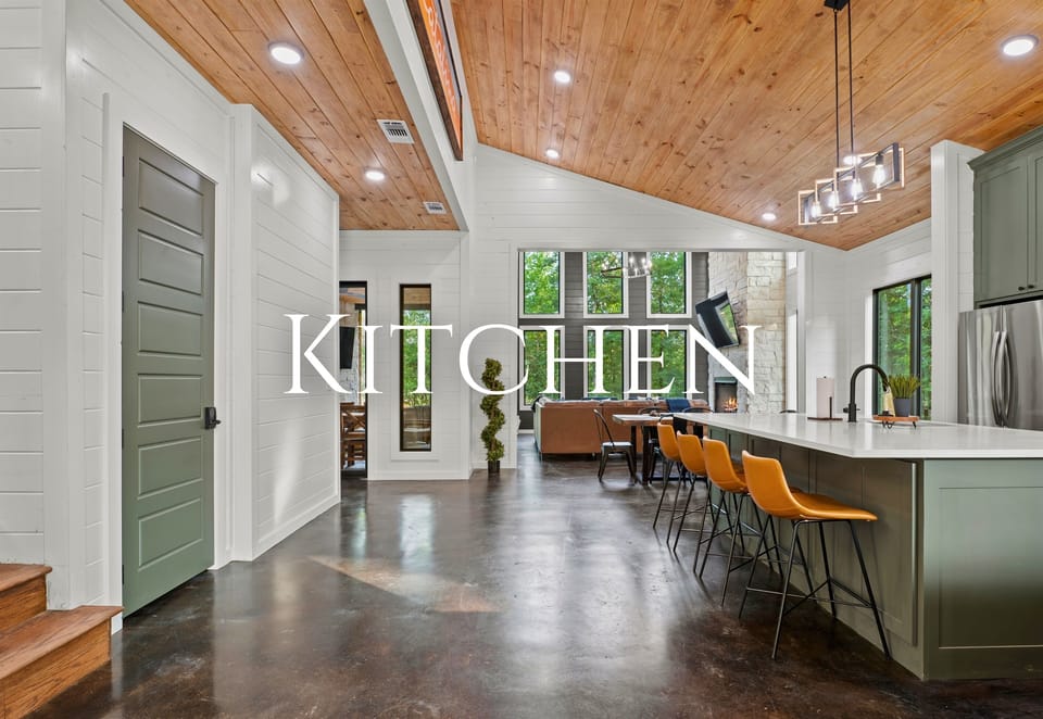 Step into a spacious kitchen with high ceilings and green accents, where natural light and modern amenities blend seamlessly.
