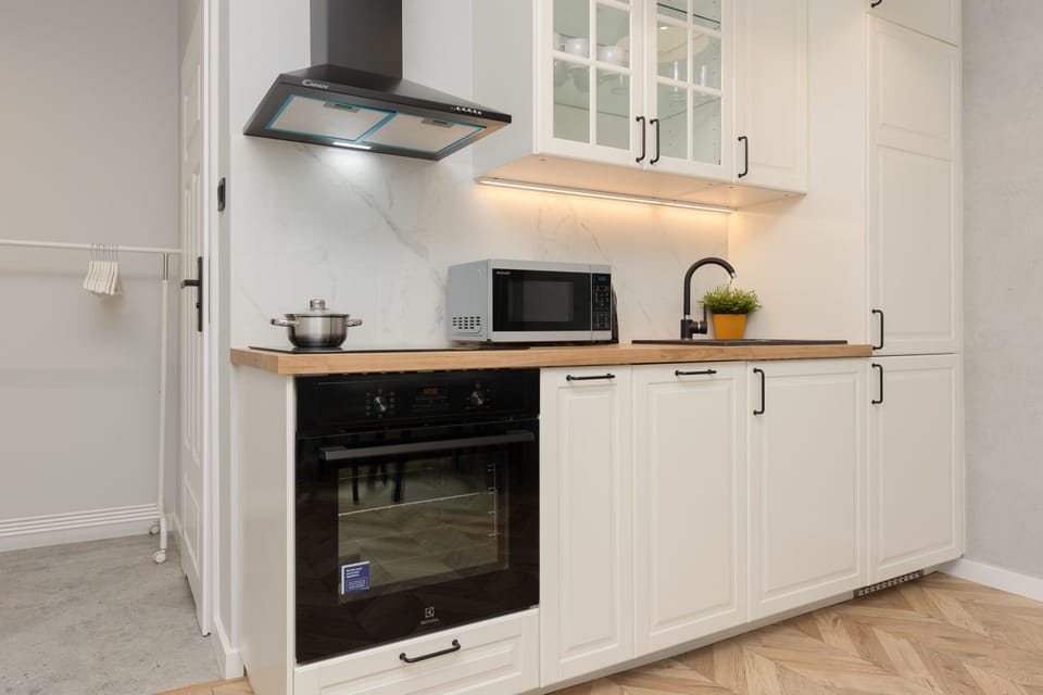 A modern kitchen with white cabinets, a built-in oven, and ample countertop space, blending style and functionality.
