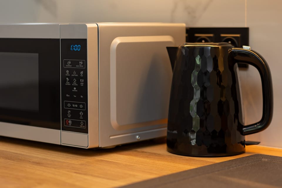 A close-up of a microwave and electric kettle, ensuring convenience for guests.
