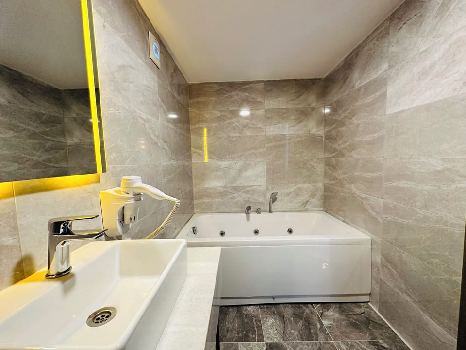Deluxe Studio Suite | Bathroom | Shower, hair dryer, slippers, towels
