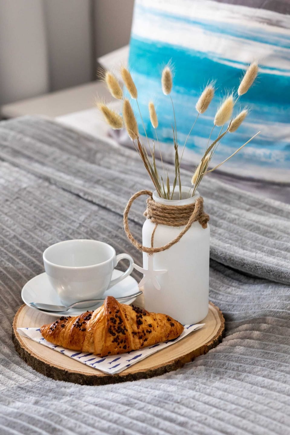 A closer look at the breakfast tray on the bed, complete with coffee and pastries, showcasing a delightful morning setup.
