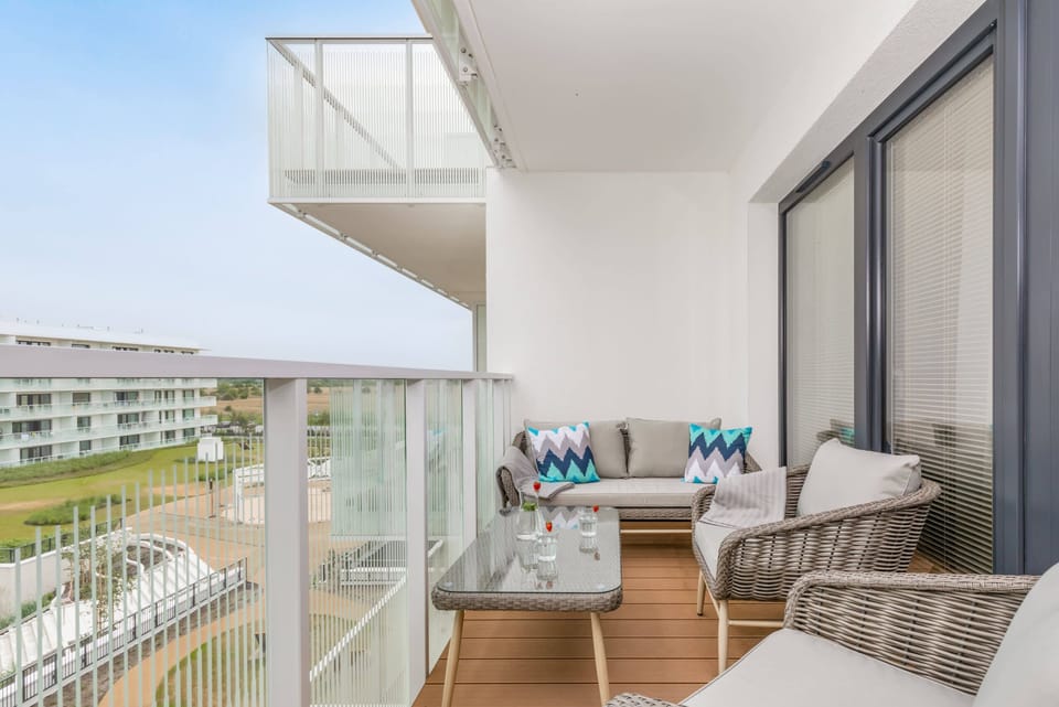 A private balcony furnished with a cozy wicker set, offering a relaxing spot to enjoy the fresh air.
