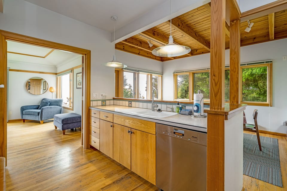 Kitchen with induction stovetop with specialty pans provided, Dishwasher, microwave, Oceanview, access to the living area.