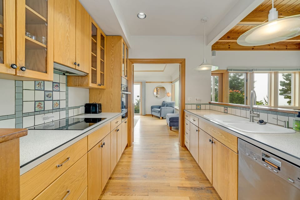 Kitchen with induction stovetop with specialty pans provided, Dishwasher, microwave, Oceanview, access to the living area.